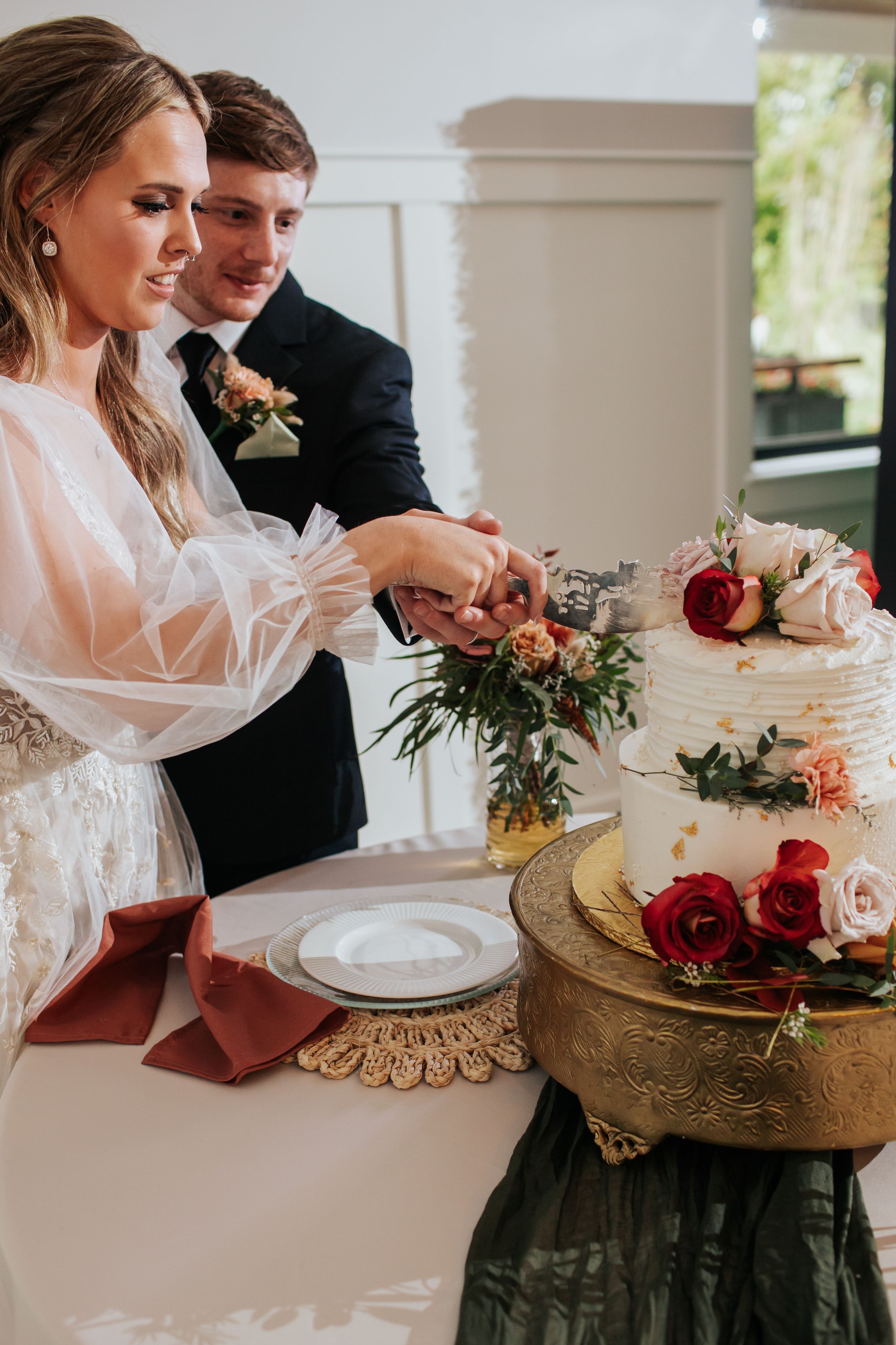 Wedding table setting with elegant floral arrangements and place settings in warm romantic lighting.