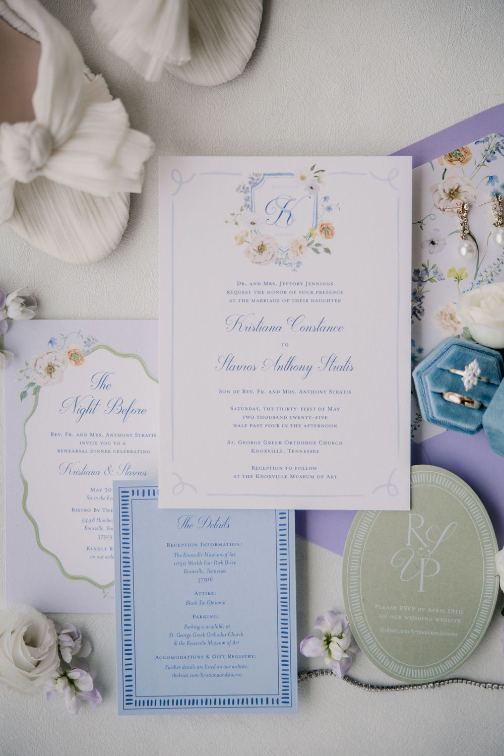Elegant wedding invitations with floral designs in soft blue and purple tones.