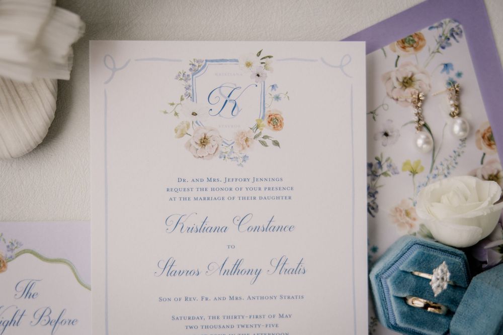 Wedding invitation suite in lavender and white with floral design elements.