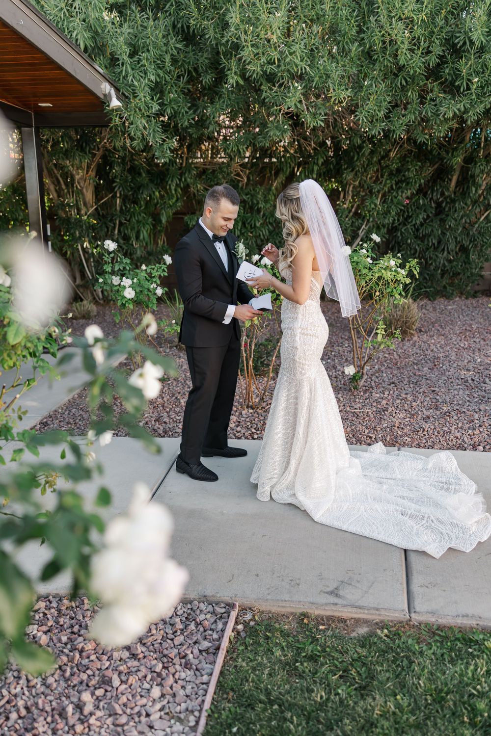 A couple shares their first look moment before their wedding ceremony in an outdoor garden setting.