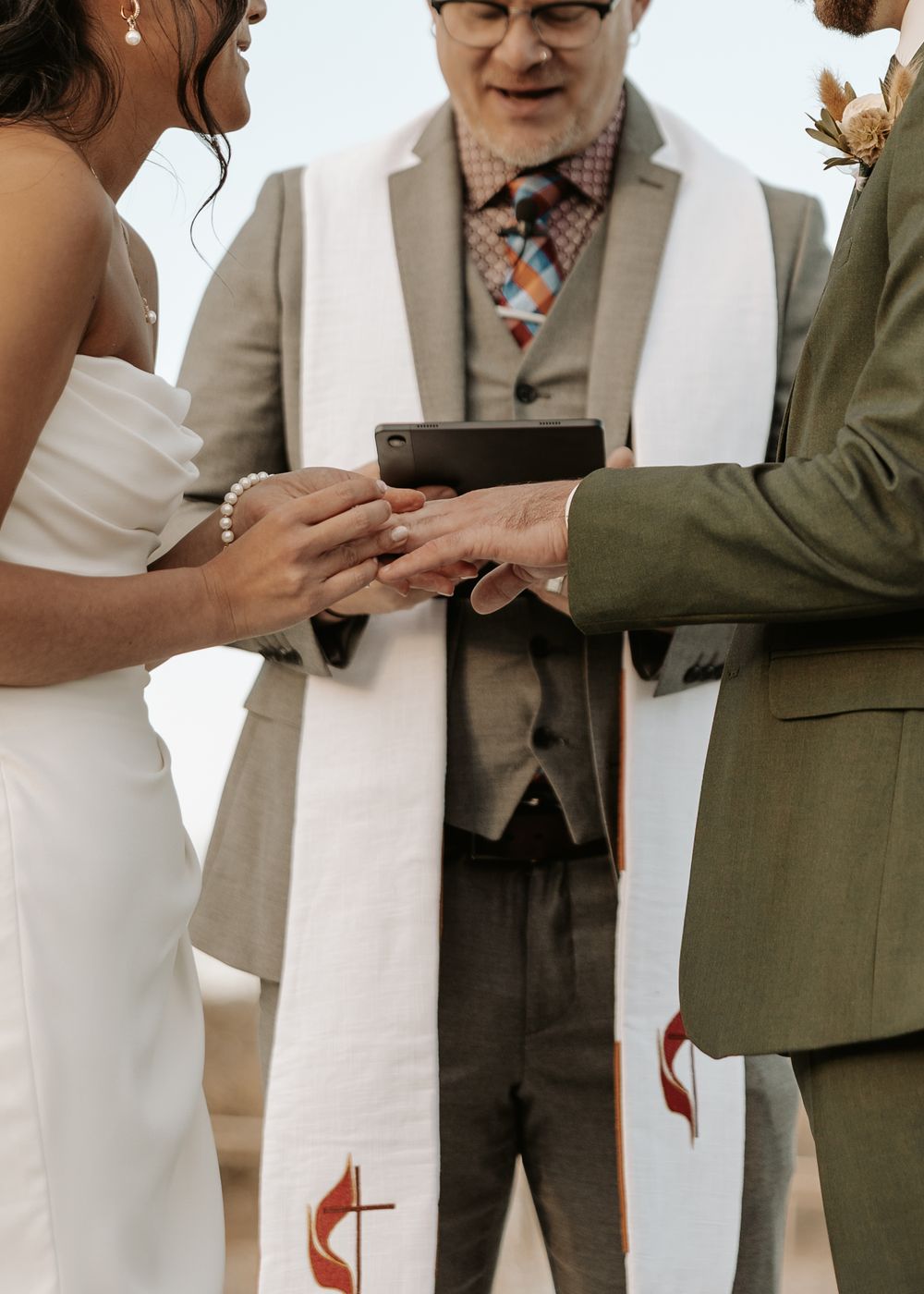 A couple exchanges rings during an intimate outdoor wedding ceremony.