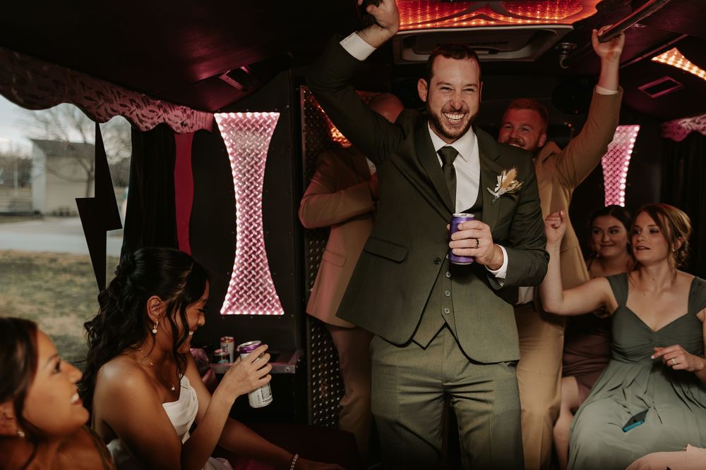 Guests celebrating at a wedding reception under red lighting and checkered decor.