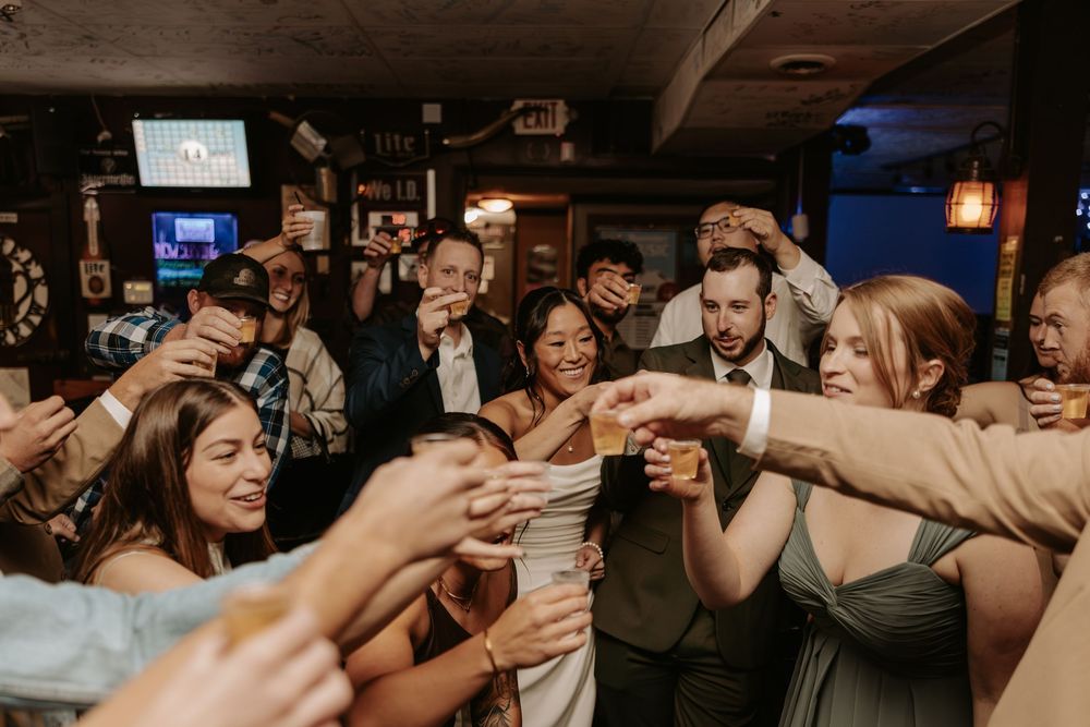 A lively group of people enjoying drinks and dancing together at a bar or tavern.