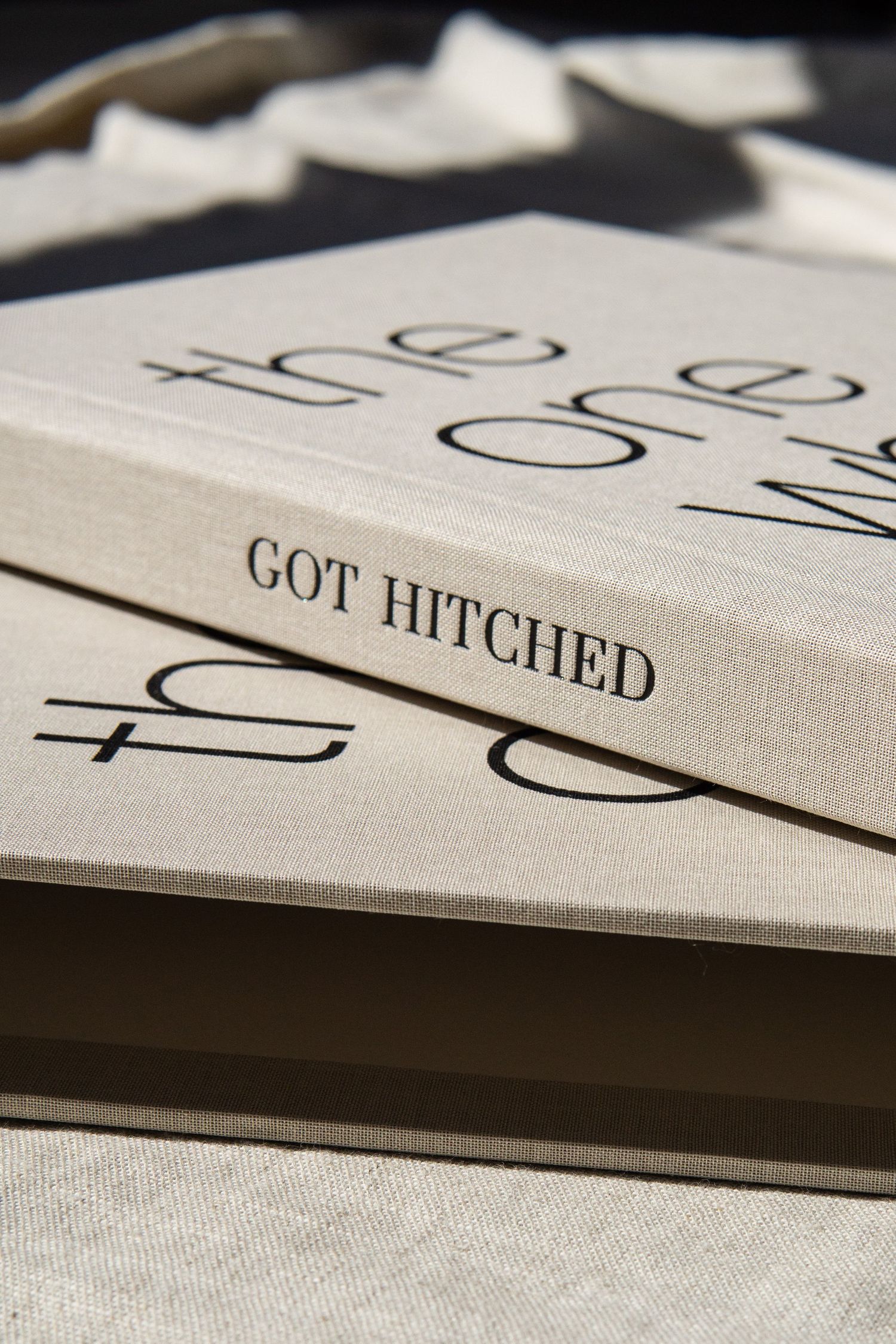 Two bright blue wedding cards with 'Oops! We got Married' text in calligraphy displayed on a gold metallic plate.