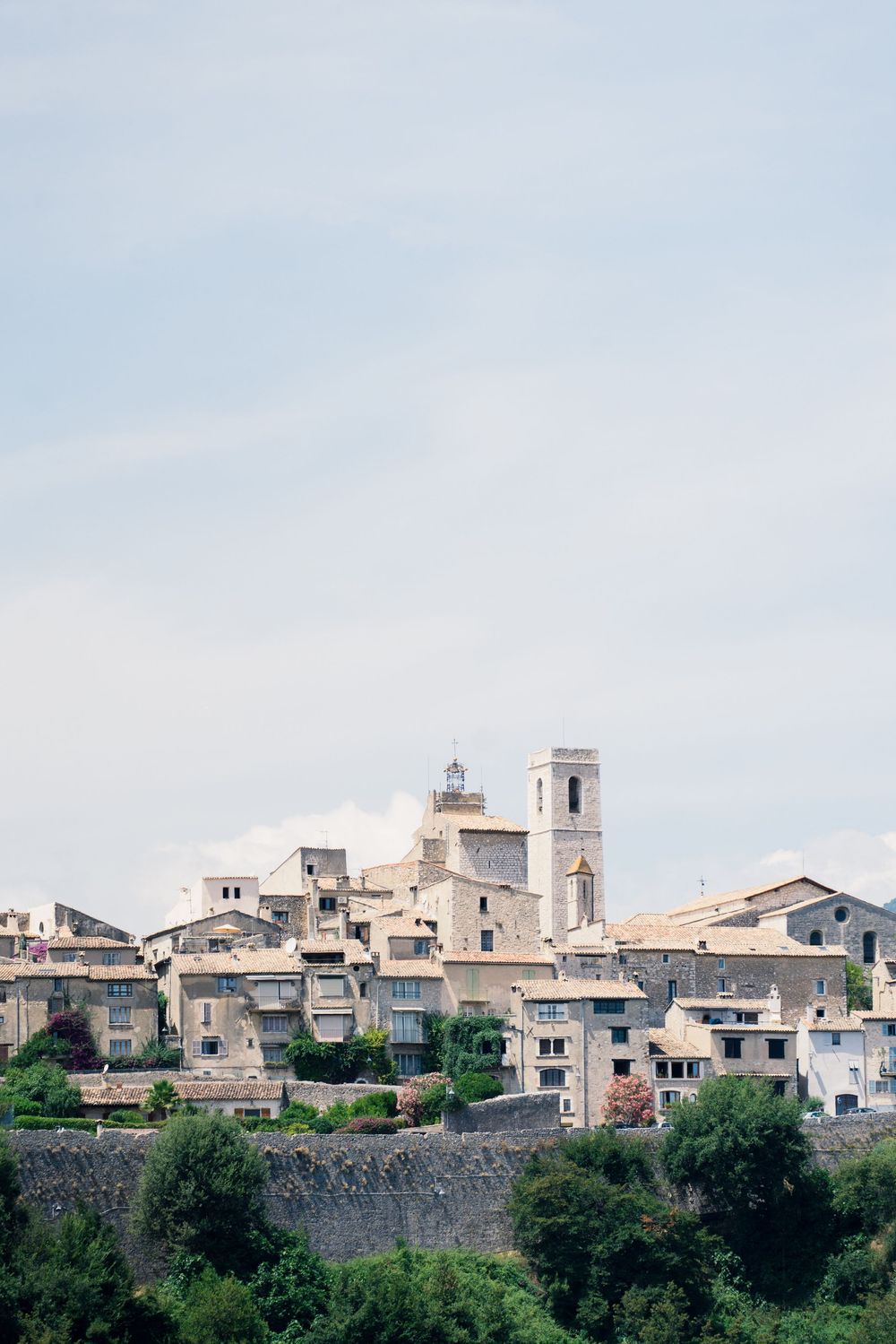 Historic Mediterranean hilltop village with stone buildings and church towers overlooking green countryside in Mallorca.