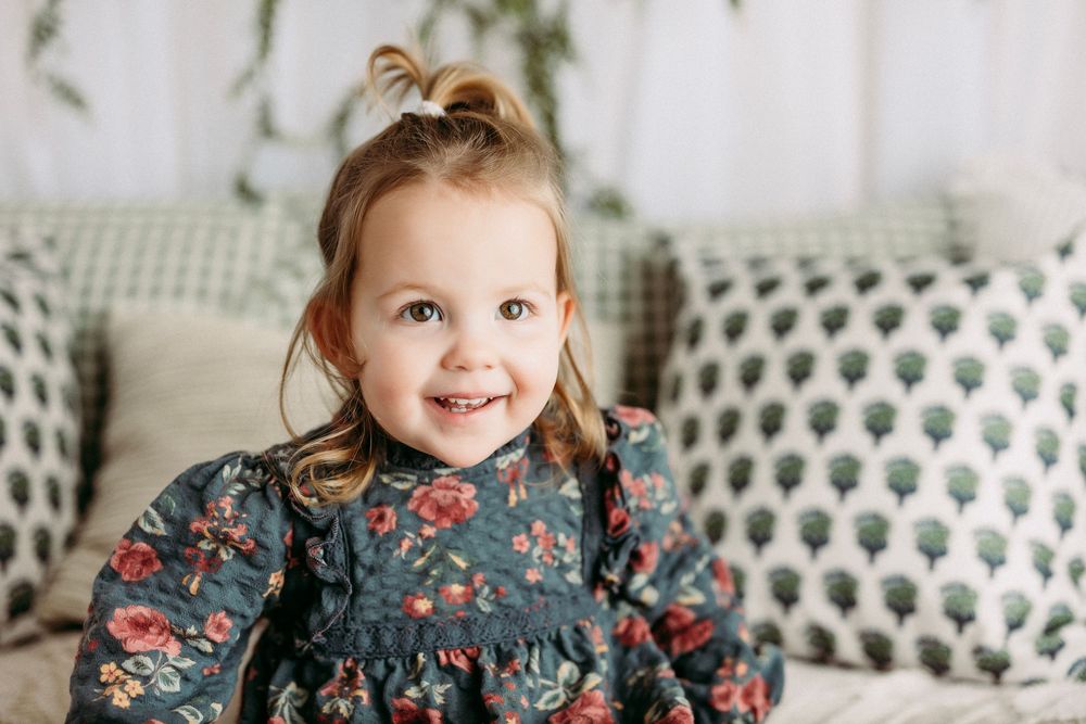 A collage of photos showing a baby in a floral dress with denim collar against a white background.