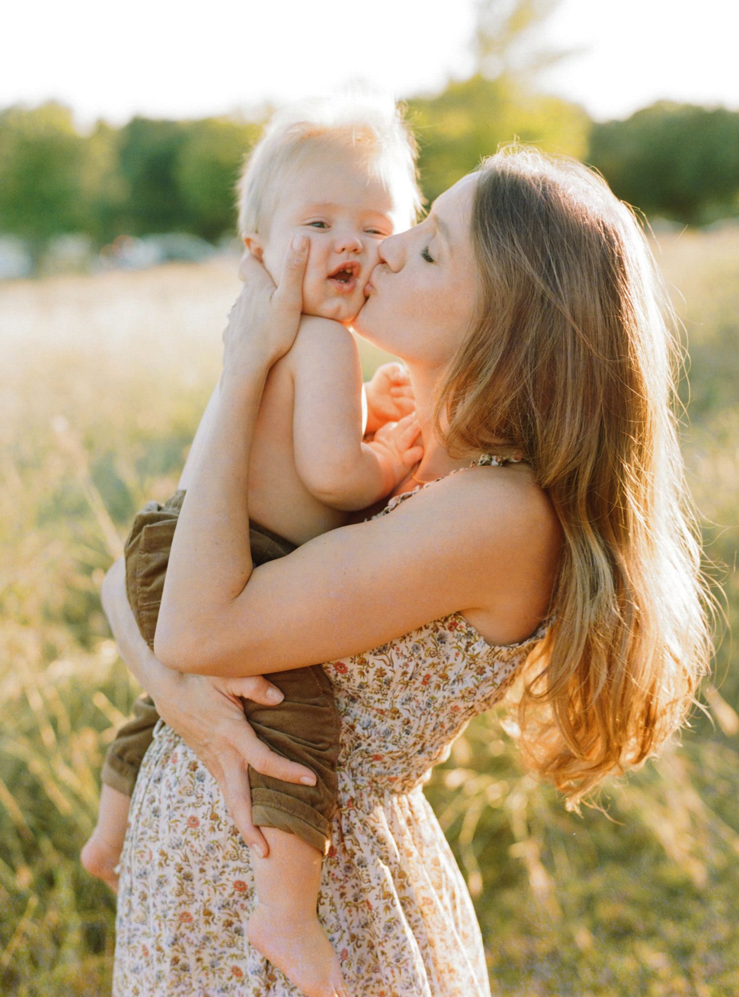 Mother embracing her daughter in a golden field at sunset