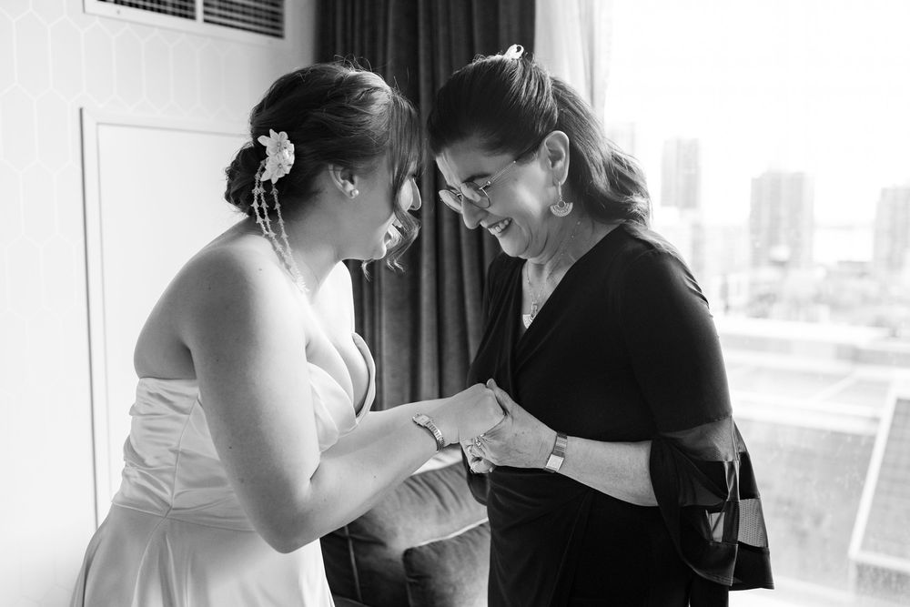 A makeup artist applies cosmetics to a client in a professional setting with natural lighting.