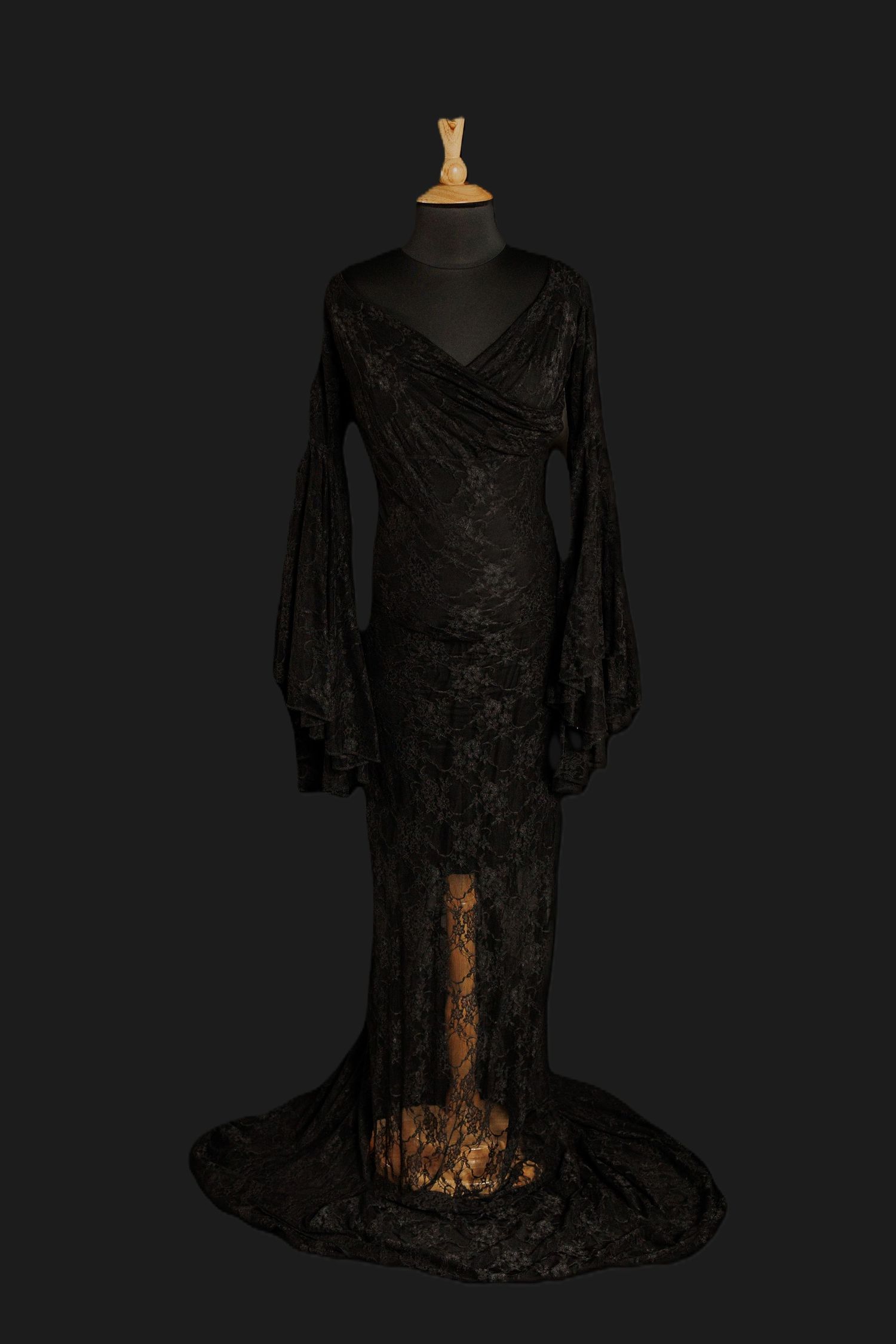 Black sheer lace maternity gown with bell sleeves, wrap-style bodice, and floor-length lace skirt on a mannequin