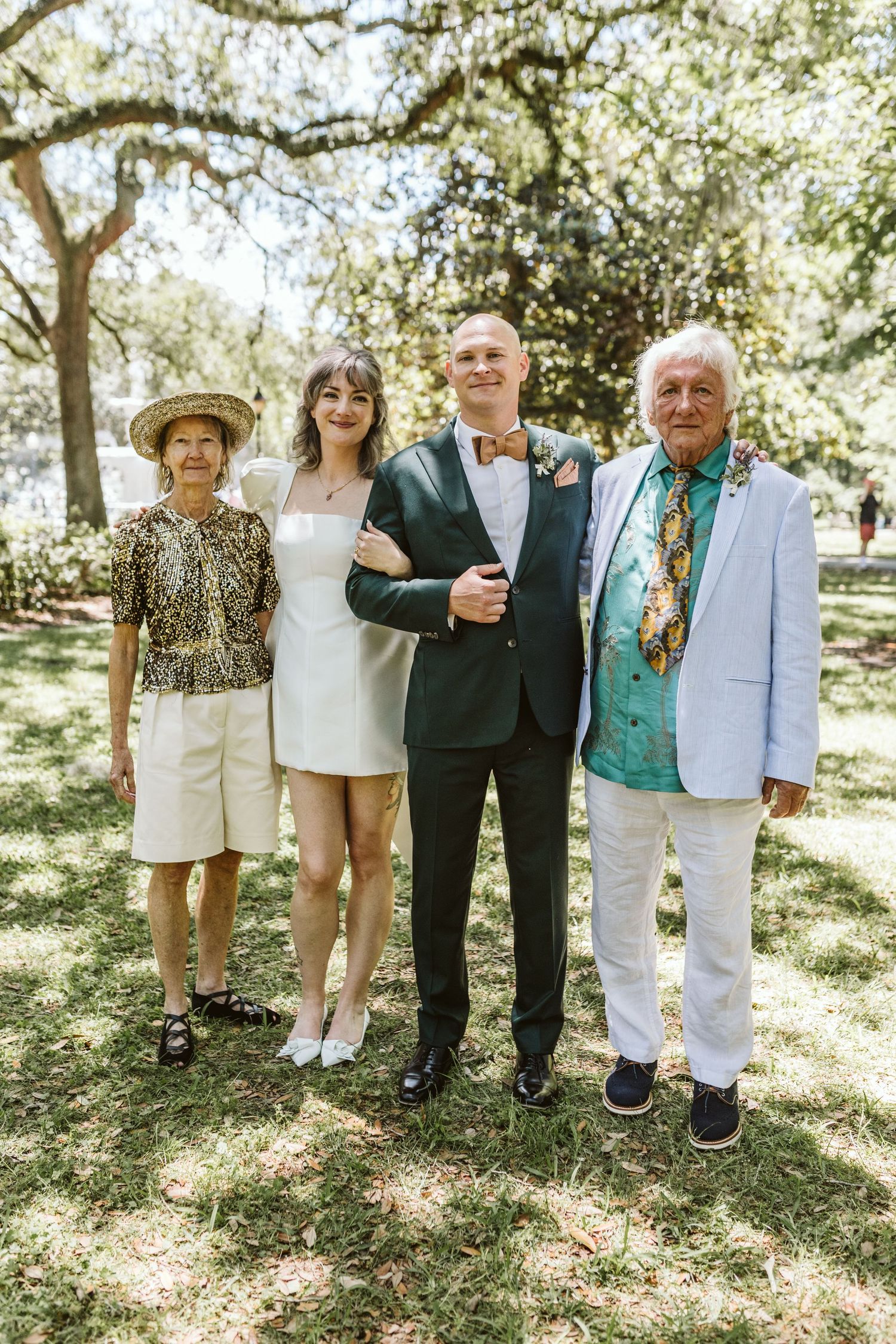 Group photo showing legs and feet of wedding attendees standing in a garden.