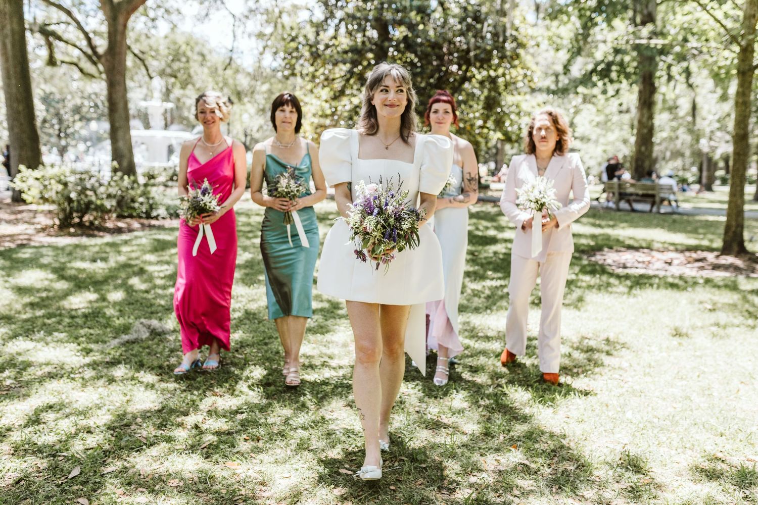 Wedding guests gather on a grassy lawn during an outdoor celebration.