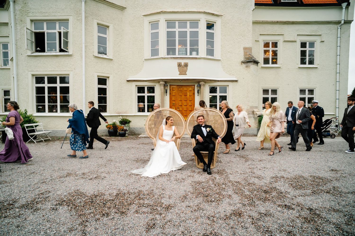 Couple in Sweden playing photo roulette together with their guests leaving and arriving for quick fun photographs on a wedding day