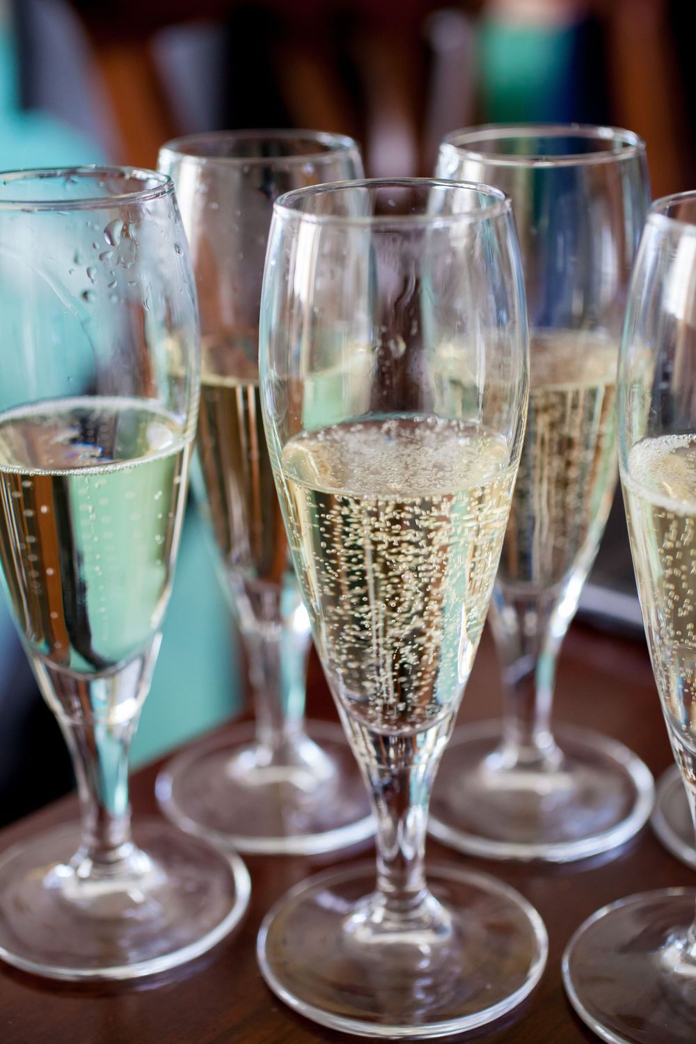 Row of champagne flutes filled with sparkling wine on display at a wedding reception.