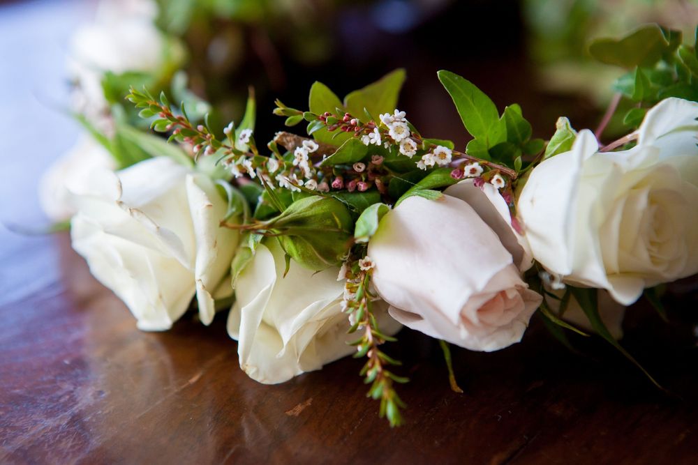 White roses and delicate greenery arranged in an elegant floral wedding decoration.