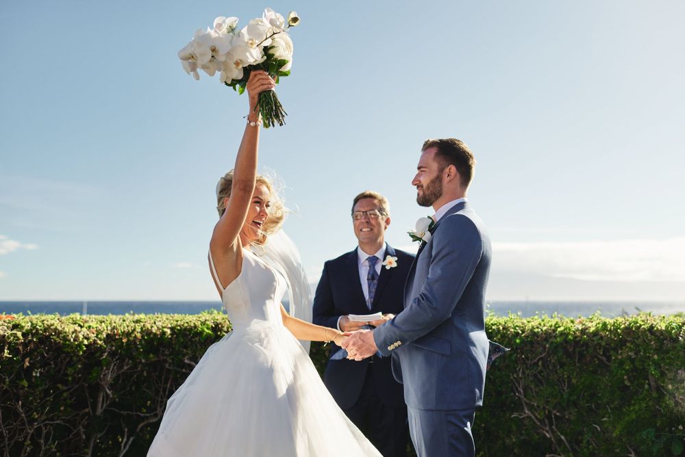 Oceanside wedding ceremony with scenic coastal views and blue skies.