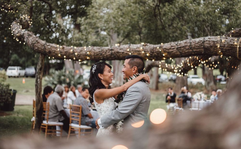 Evening wedding reception setup with string lights and rustic wooden elements.