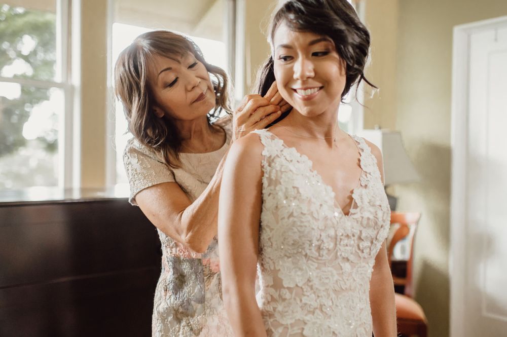 Getting ready moments in a sunlit room with elegant wedding attire.