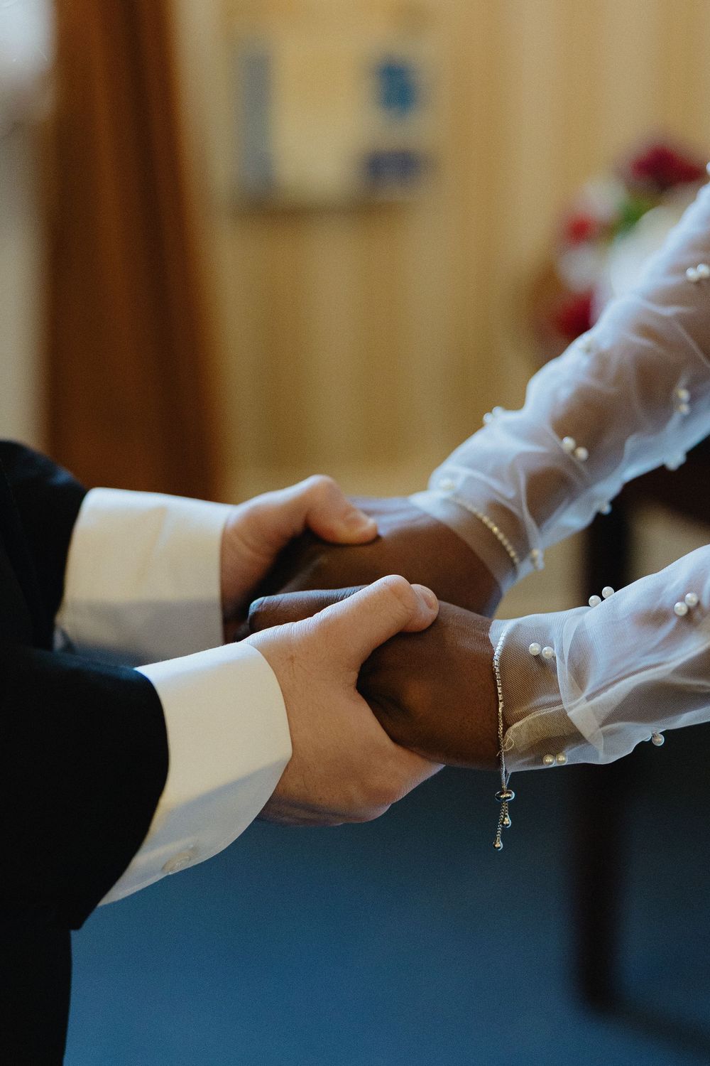 Close-up sequence of hands clasping together in a formal setting.
