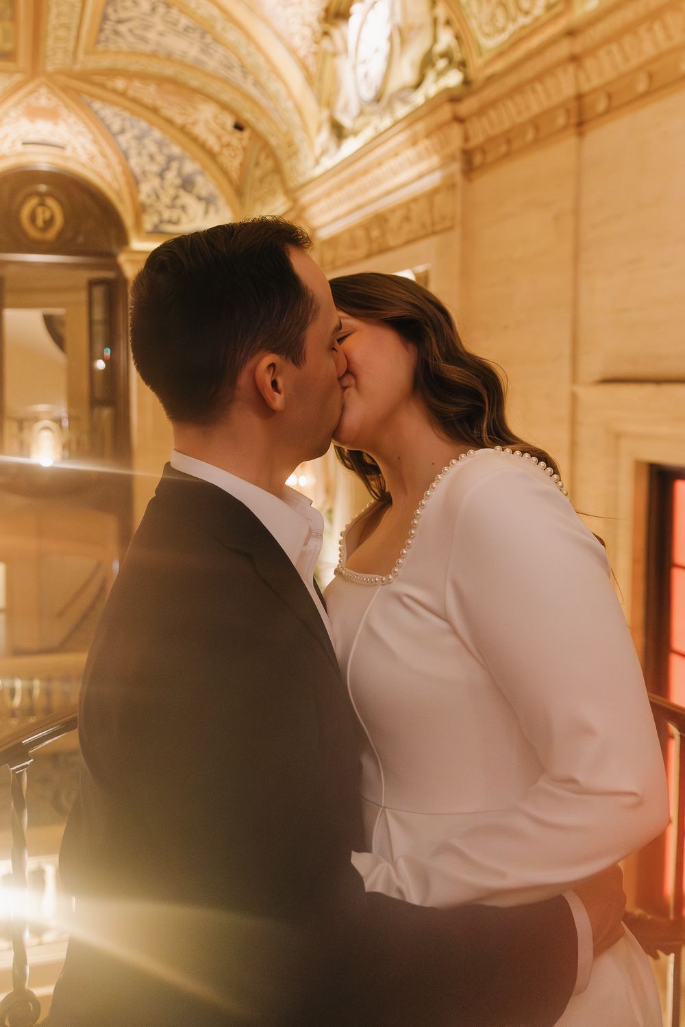 A romantic wedding kiss sequence captured in an elegant ballroom with ornate gold decor and warm lighting.