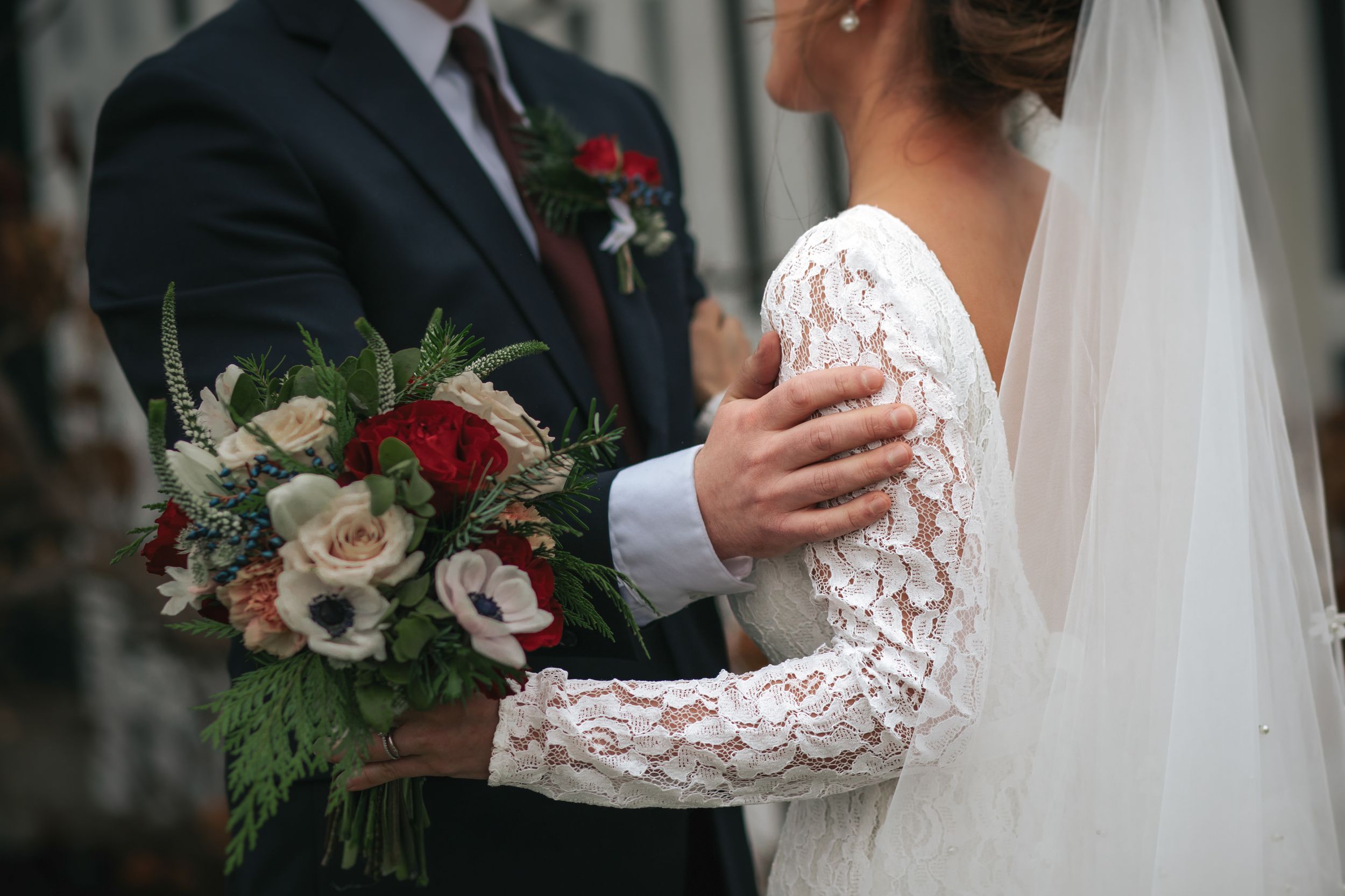 A romantic wedding moment captured with elegant floral bouquets and delicate lace details in a soft, natural setting.