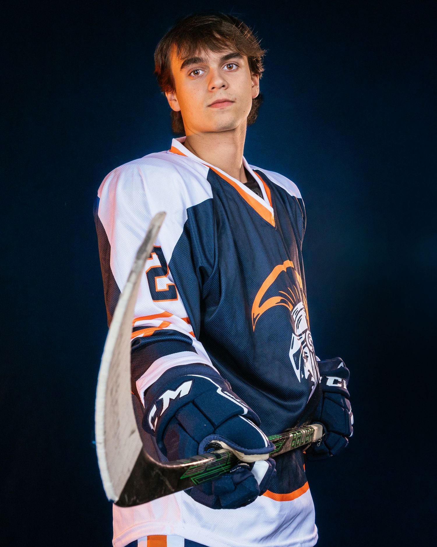 Hershey Trojans high school hockey player portrait in blue jersey, dramatic lighting, Central Pennsylvania, by SportsFox Photography,