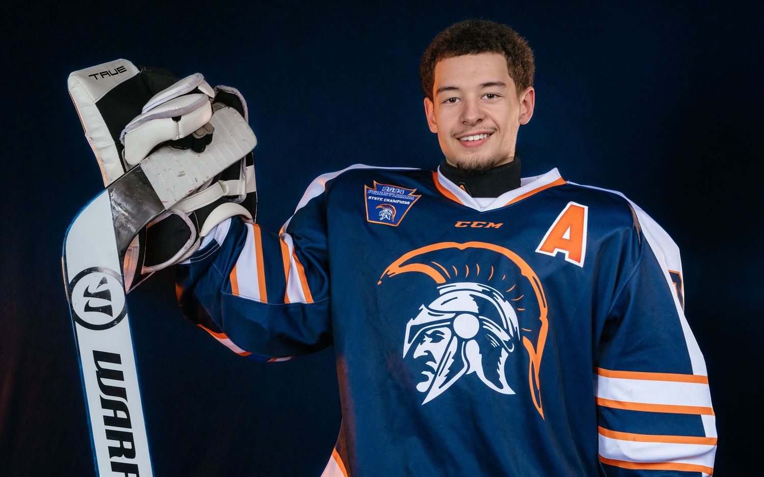 Hershey Trojans high school hockey goalie portrait in blue jersey, dramatic lighting, Central Pennsylvania, by SportsFox Photography