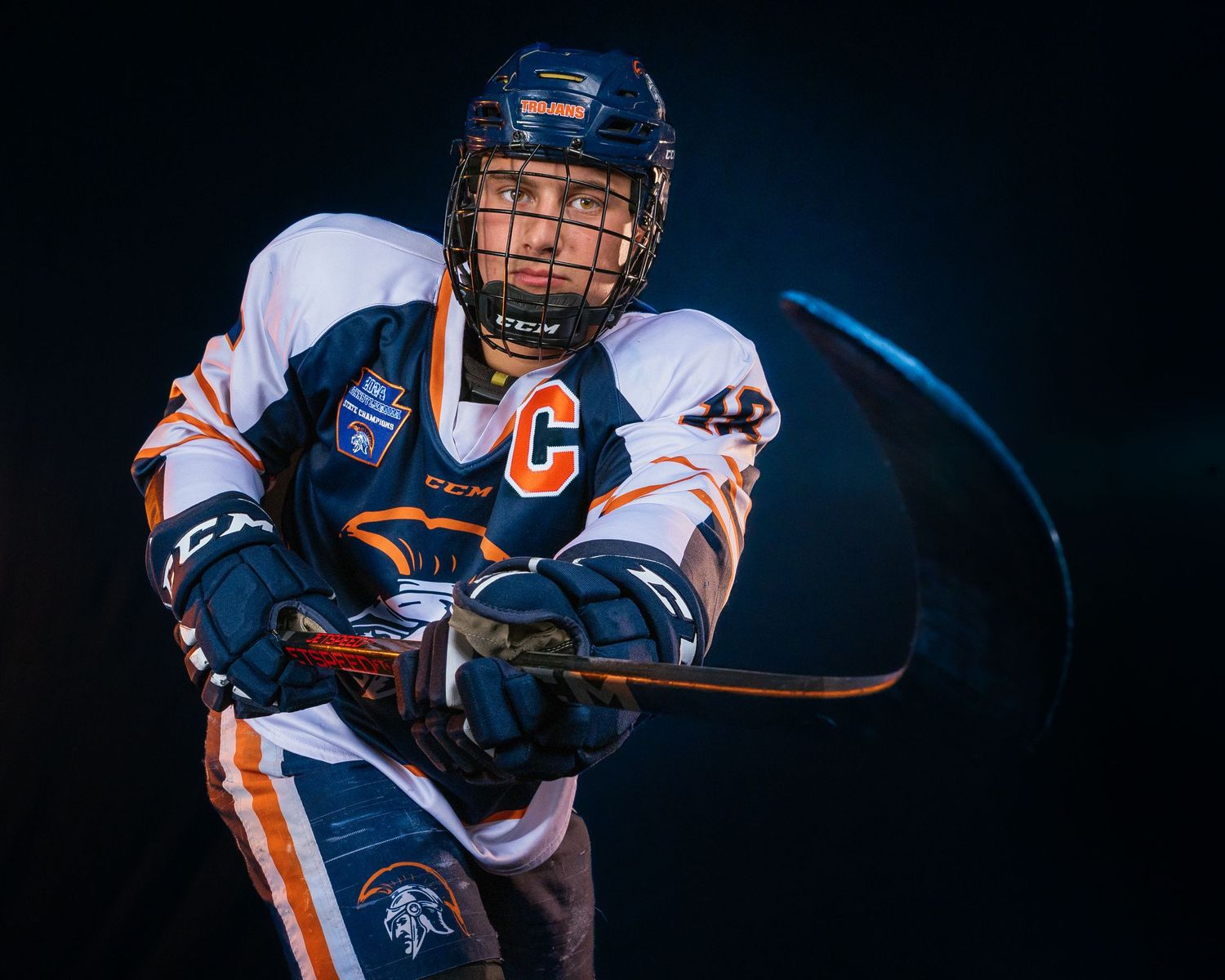 Hershey Trojans high school hockey player portrait in blue jersey, dramatic lighting, Central Pennsylvania, by SportsFox Photography,