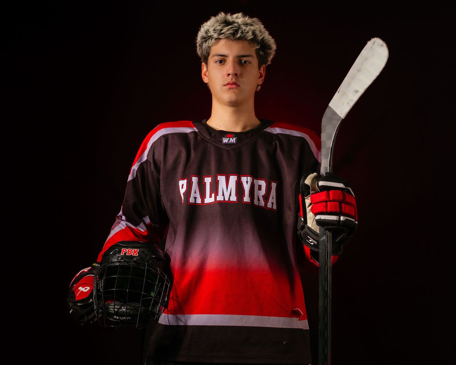 Palmyra Black Knights high school hockey player portrait in red jersey, dramatic lighting, Central Pennsylvania, by SportsFox Photography