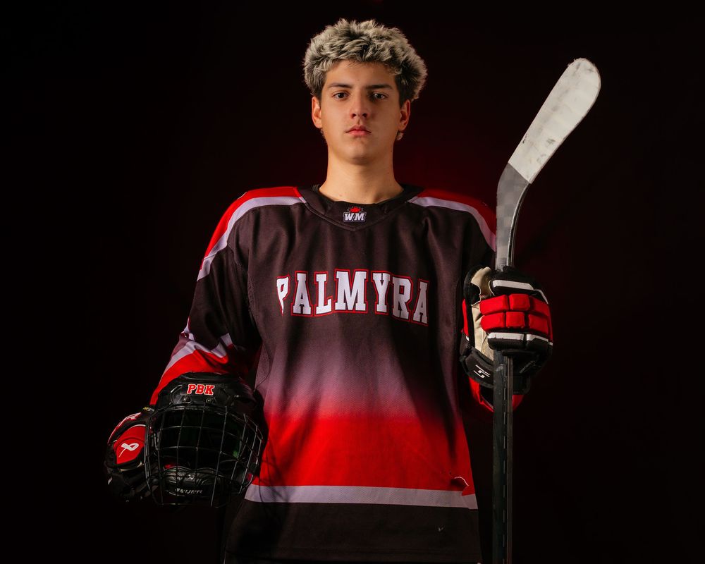 Palmyra Black Knights high school hockey player portrait in red jersey, dramatic lighting, Central Pennsylvania, by SportsFox Photography