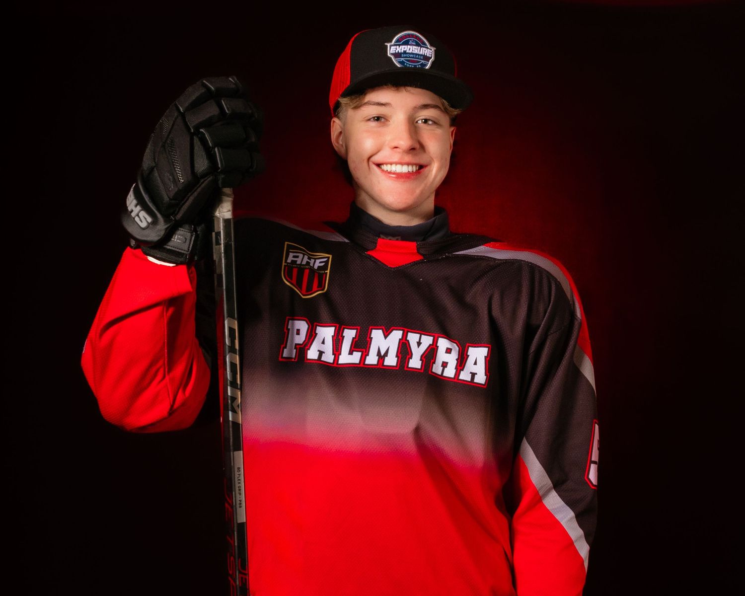 Palmyra Black Knights high school hockey player portrait in red jersey, dramatic lighting, Central Pennsylvania, by SportsFox Photography