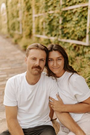 A couple in matching white t-shirts share intimate moments in a series of candid outdoor photos.