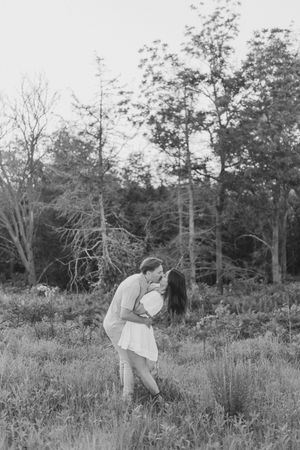 A romantic black and white photo sequence shows a couple embracing in a meadow surrounded by trees.