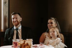 Wedding reception guests enjoying dinner and conversation at decorated tables.