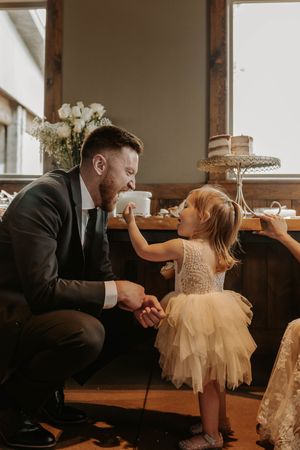 A heartwarming series of playful interactions between a couple and a young child at a wedding reception.