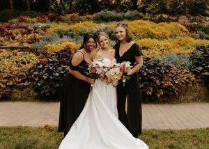 Wedding party poses in a garden setting with vibrant yellow autumn foliage creating a warm backdrop.