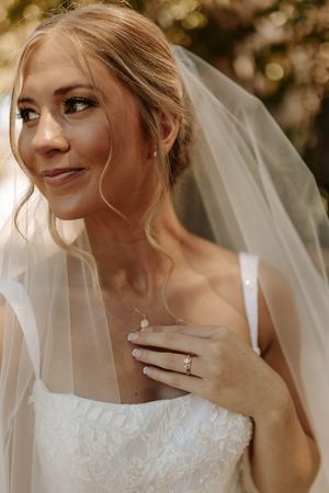 Close-up artistic shots of a bride wearing a delicate veil in warm natural lighting.