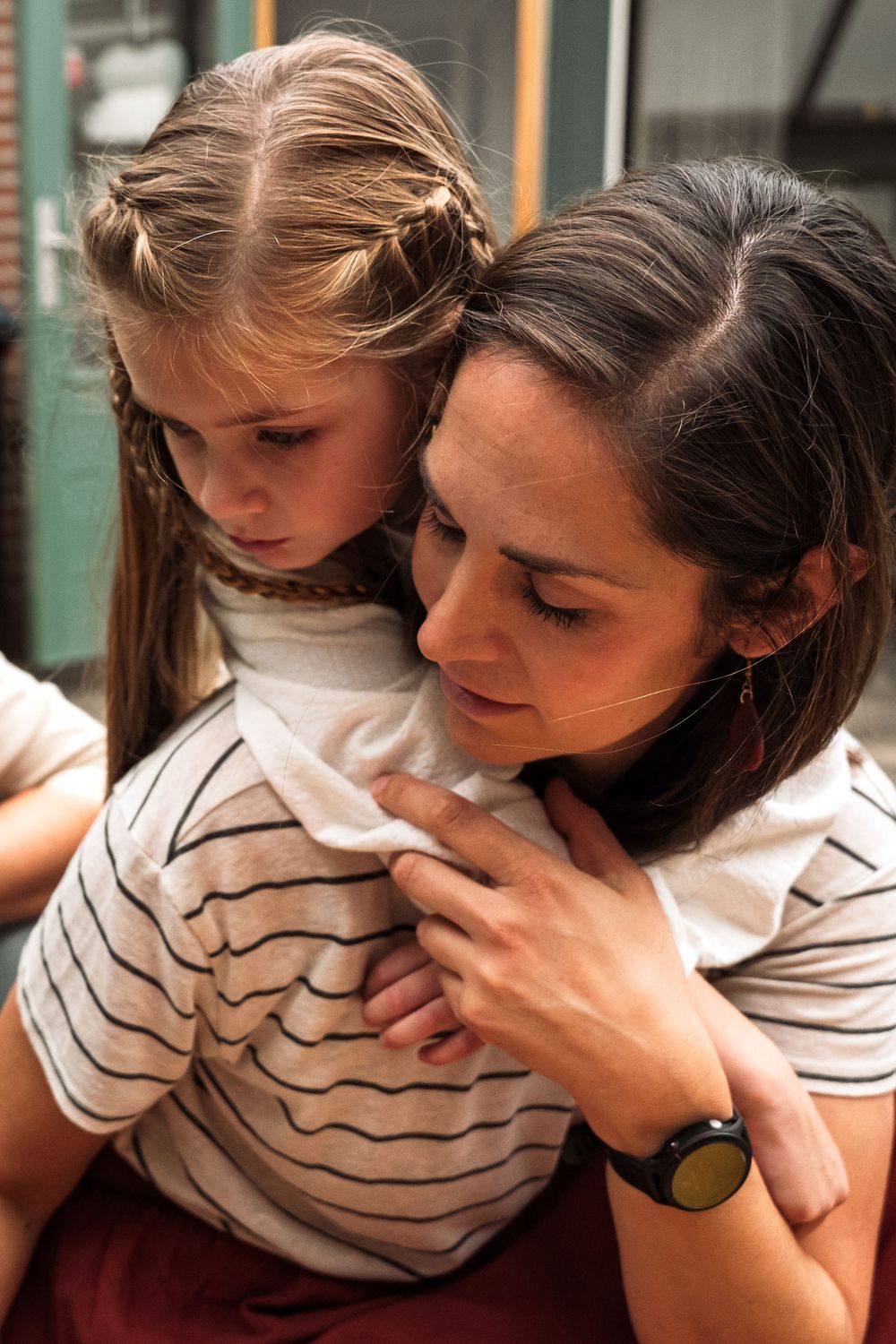 A series of tender moments between parent and child in matching striped shirts shown in multiple connected photos.