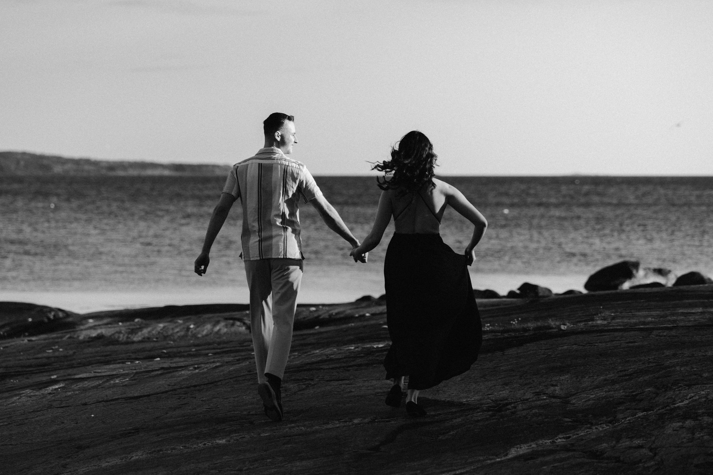 Silhouetted figures create romantic poses against a coastal backdrop.