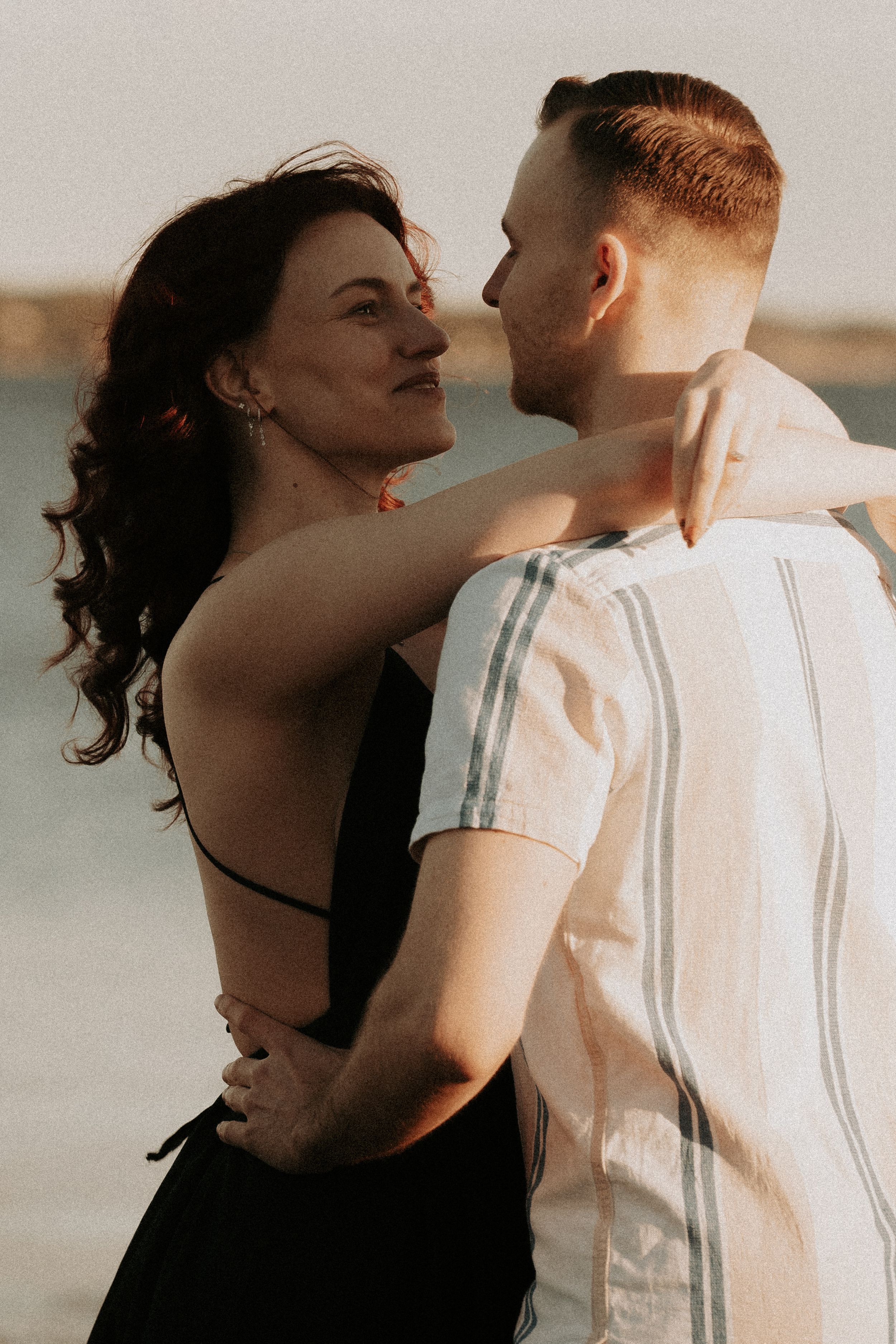 Close-up romantic moment captured against a seaside background.
