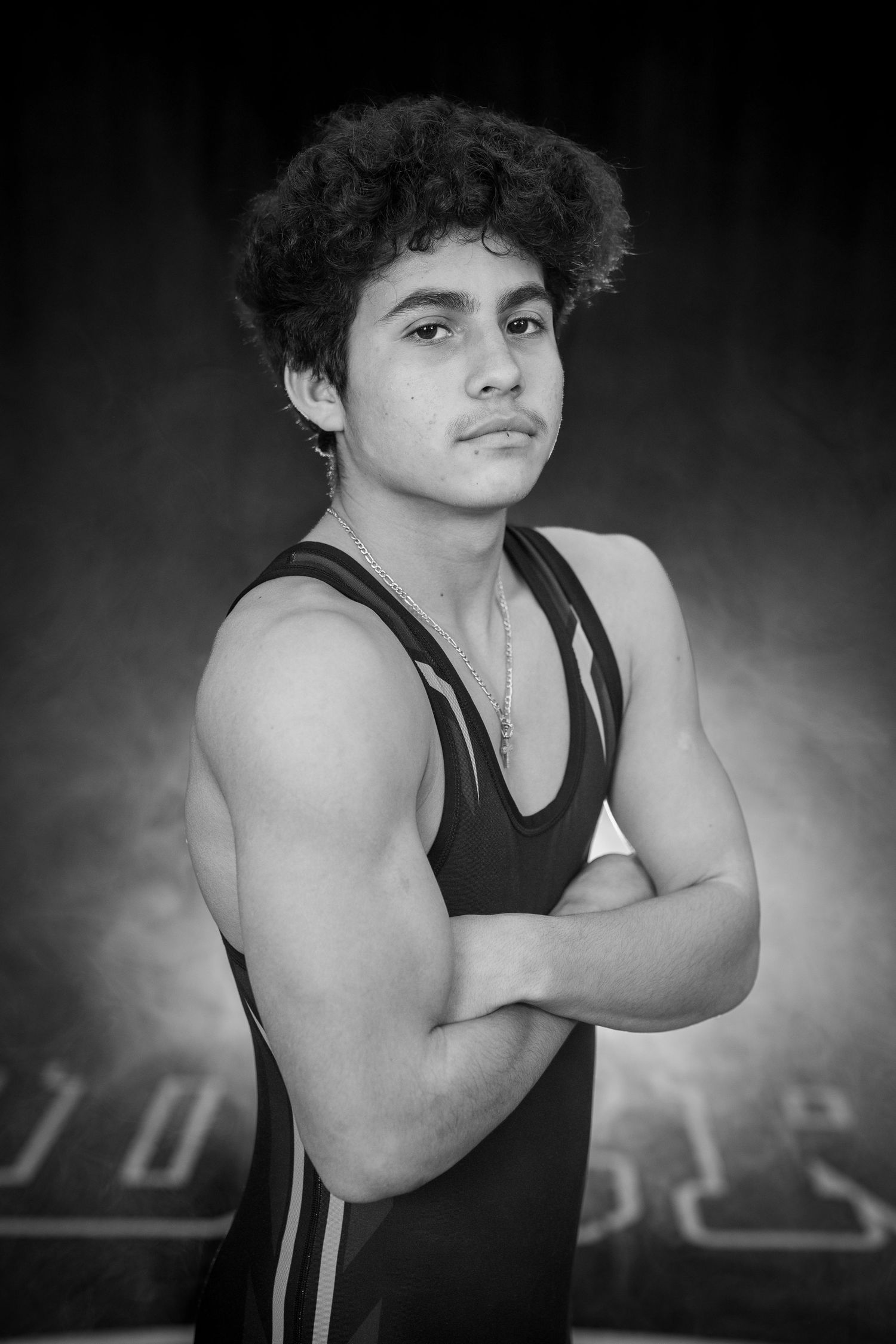 Black and white sequence showing a wrestler in a dark singlet striking different athletic poses during a photo shoot.