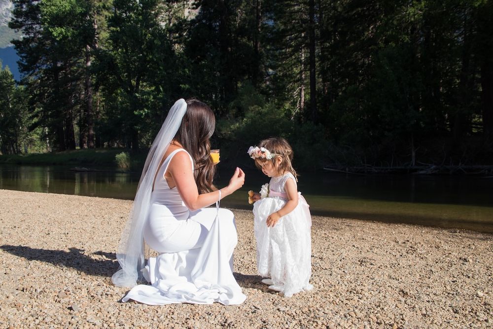 A series of tender moments between a parent and child sitting together on a sandy beach in white clothing.