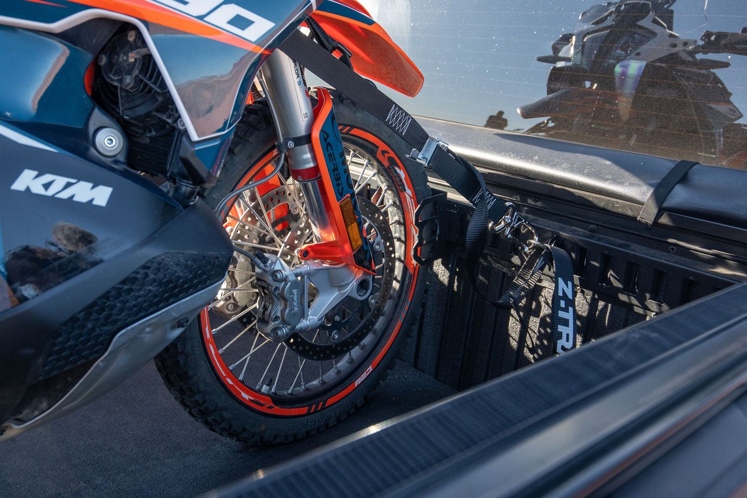 Sequence of motorcycle rider performing backflip stunts against blue sky.