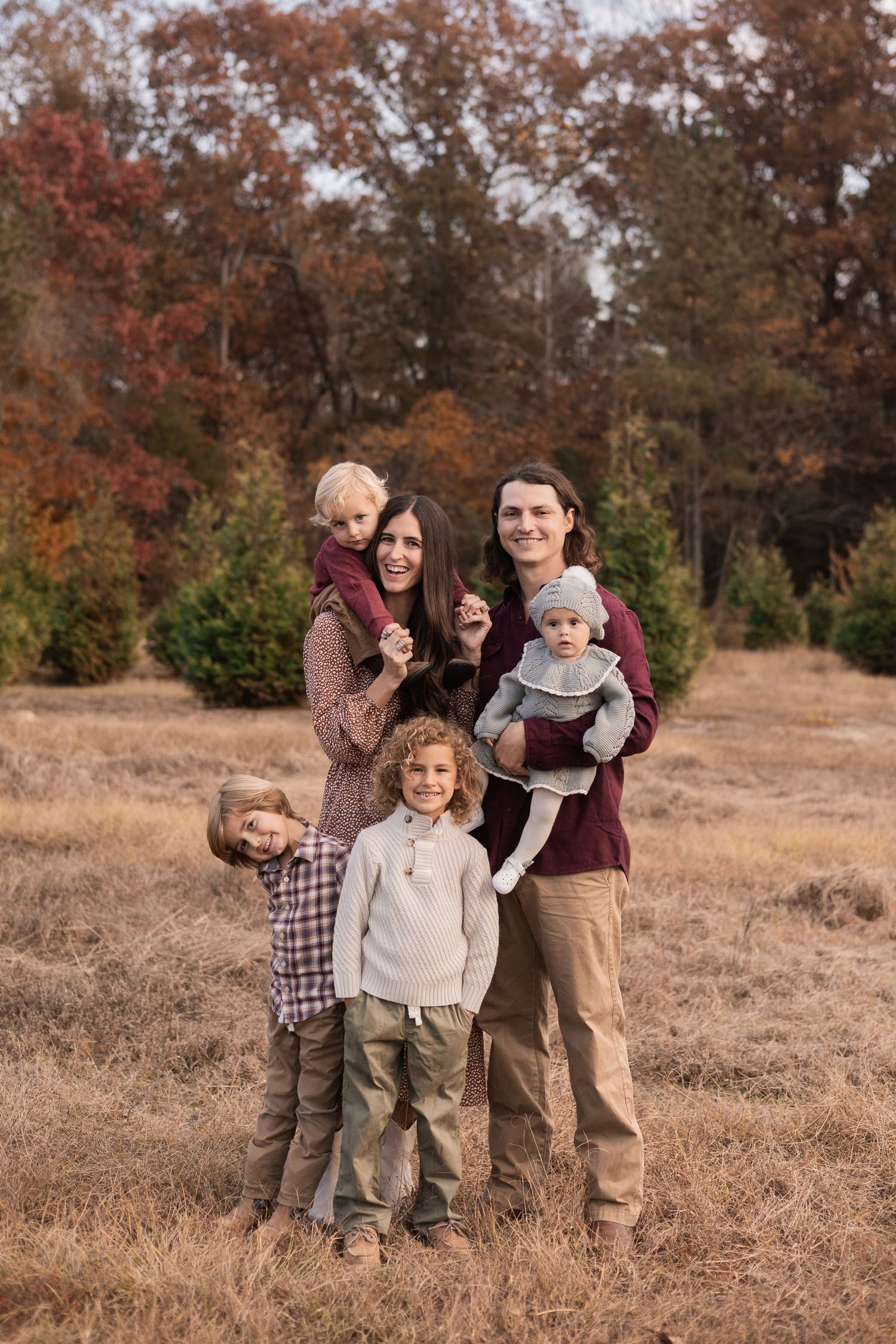 Family of 6 outdoor family session on their Wilmington property with 2 year old on mom’s shoulders, and 5 year old being silly