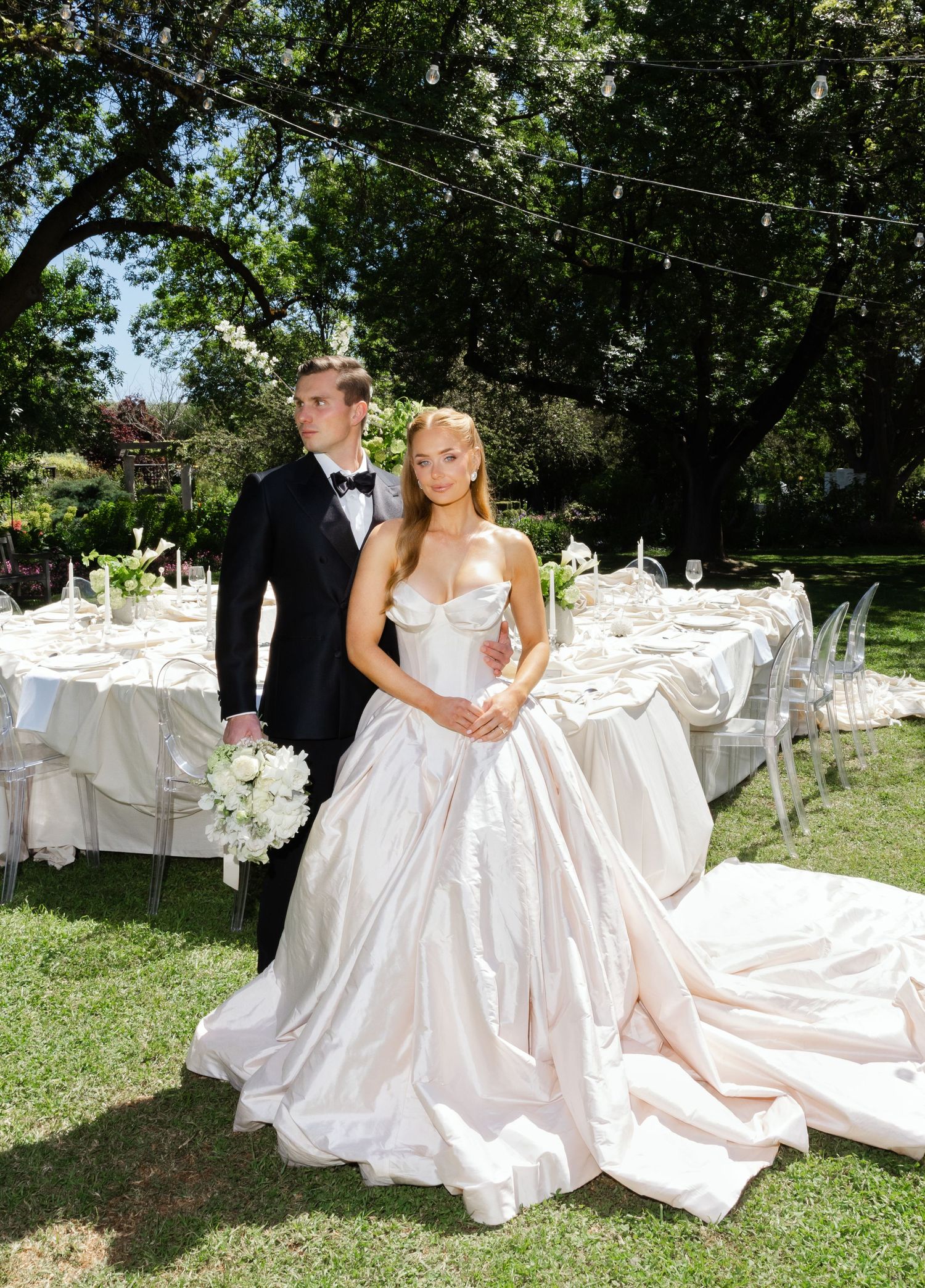 Elegant outdoor garden wedding reception setup with white tables and a couple at Al Ru Farm in Adelaide taken by wedding photographer.