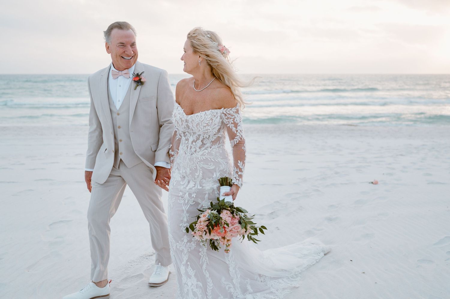 A romantic beachside moment with a couple embracing on the sandy shore during a dreamy sunset.