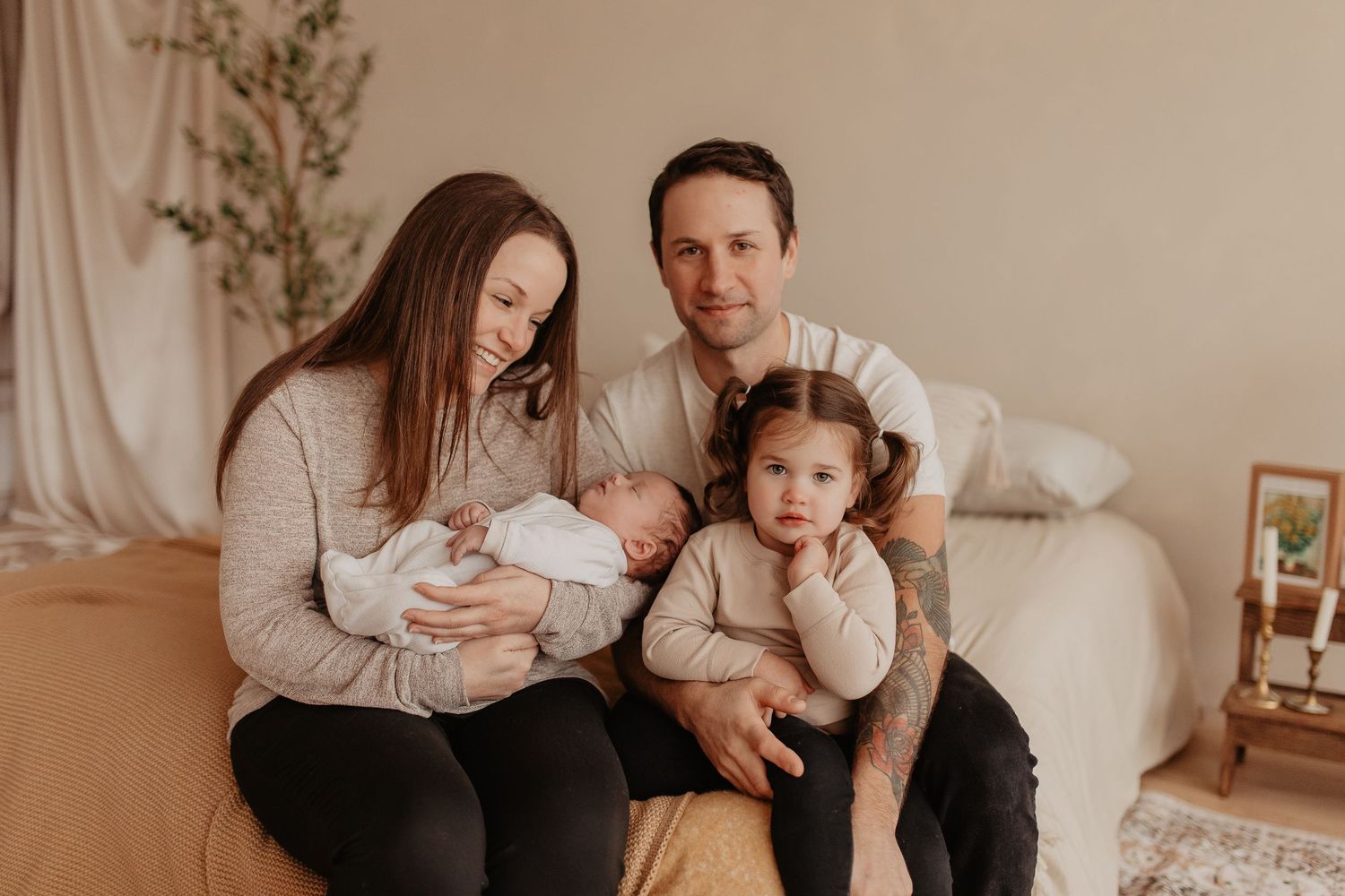 Family members share tender moments together in a warm-toned studio setting with neutral decor.