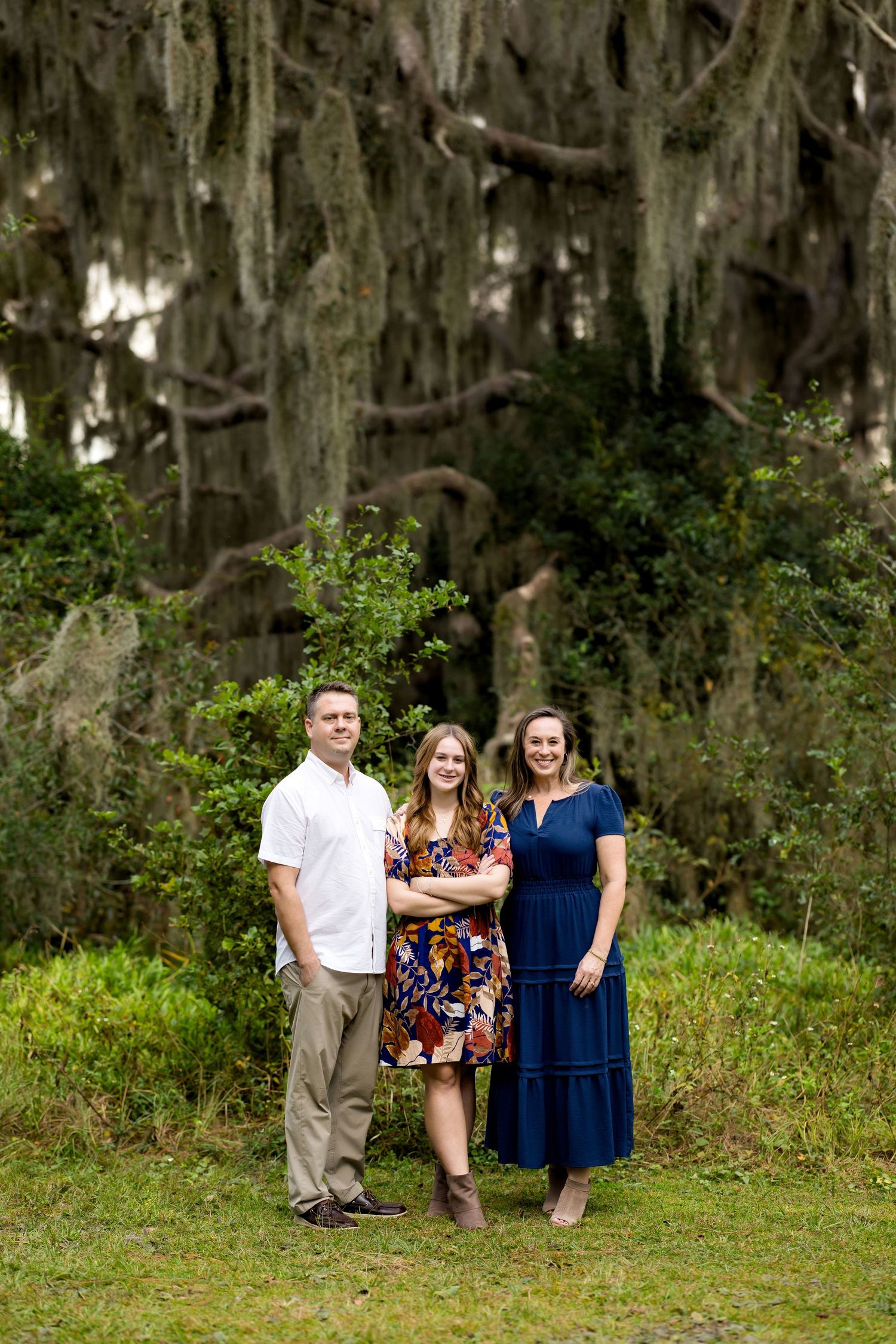A group stands together under Spanish moss draped trees in an outdoor setting.