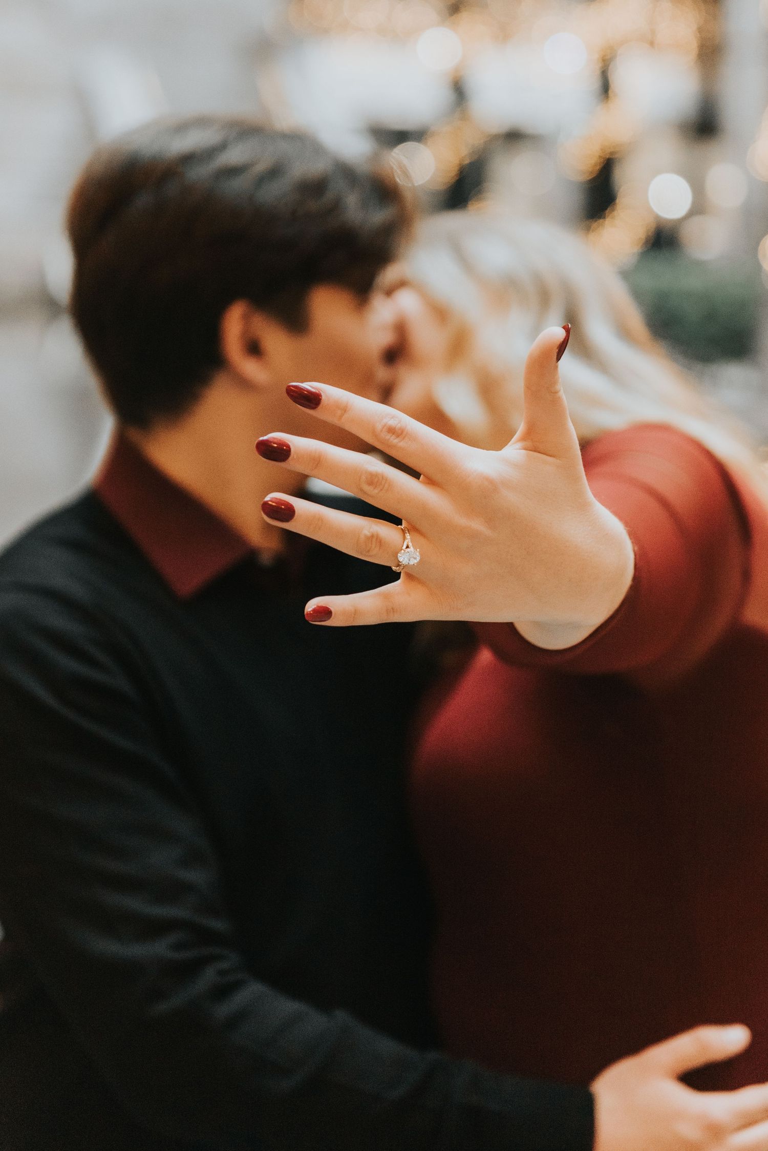A close-up series of hands showing an engagement ring in warm lighting with romantic bokeh effect in background.
