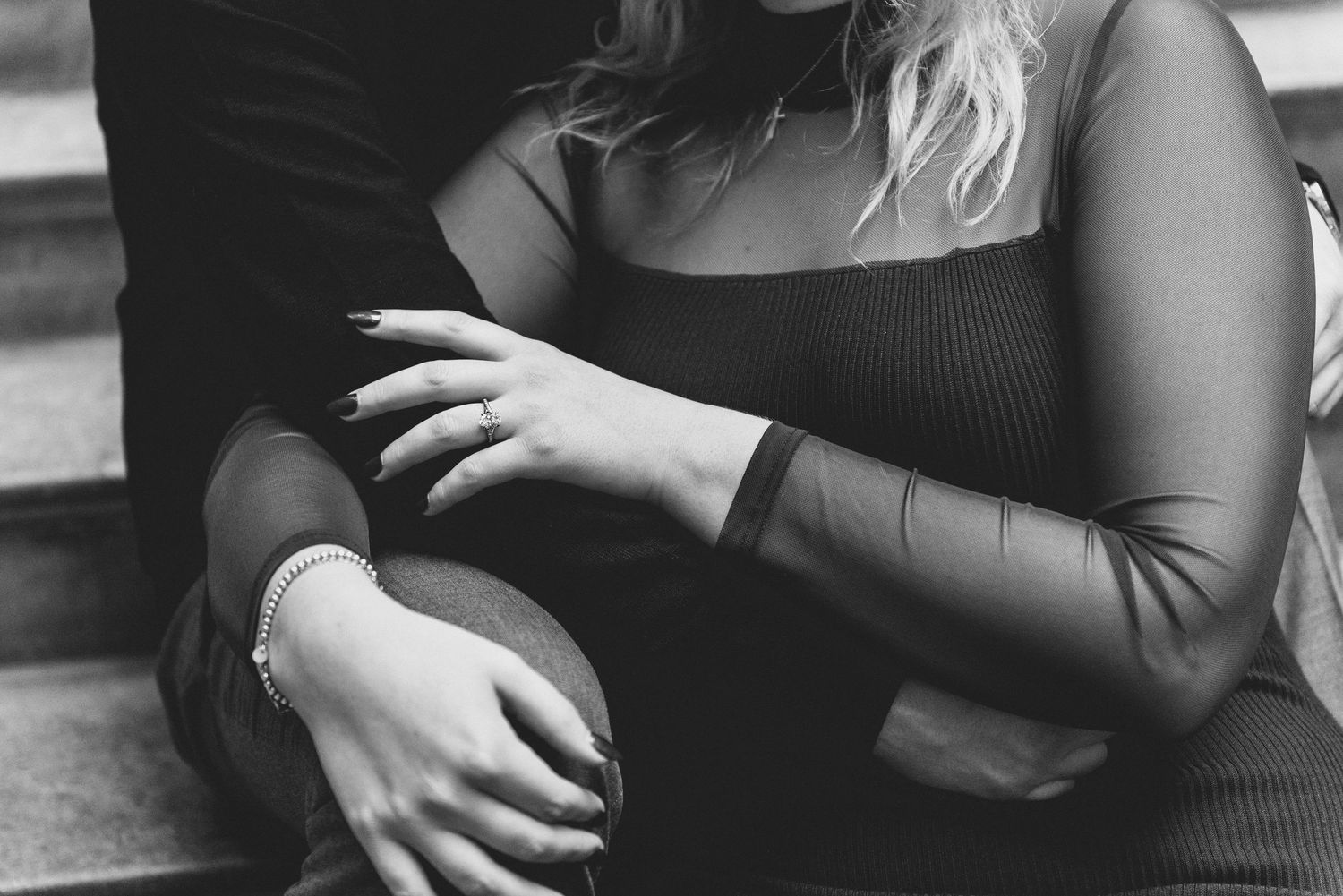 A black and white photo shows a couple embracing in an intimate moment during a dance.
