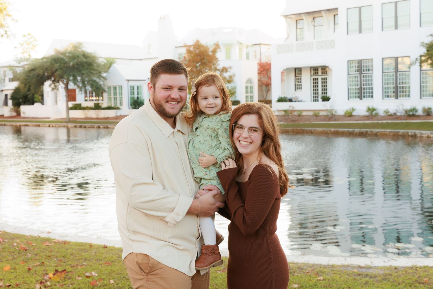 A couple shares joyful moments by a scenic lakefront during an autumn photoshoot.